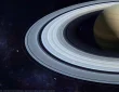 Deep space telescope image of Saturn and faint points of light in distant orbits