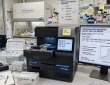 Scientist analysing tumour DNA sequences on screens in a research laboratory