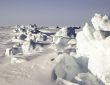 broken arctic sea ice floating on dark ocean water