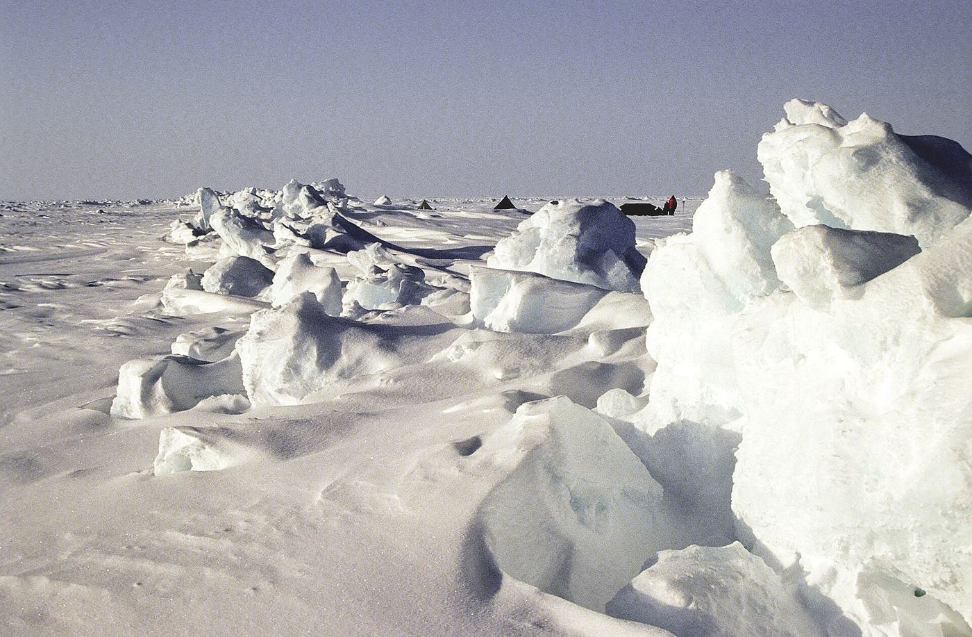 broken arctic sea ice floating on dark ocean water