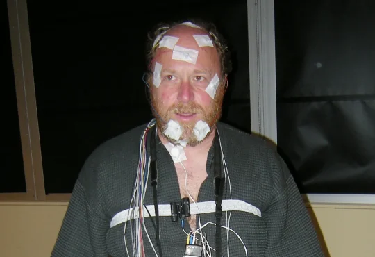 A volunteer wired with sensors during a sleep study in a laboratory