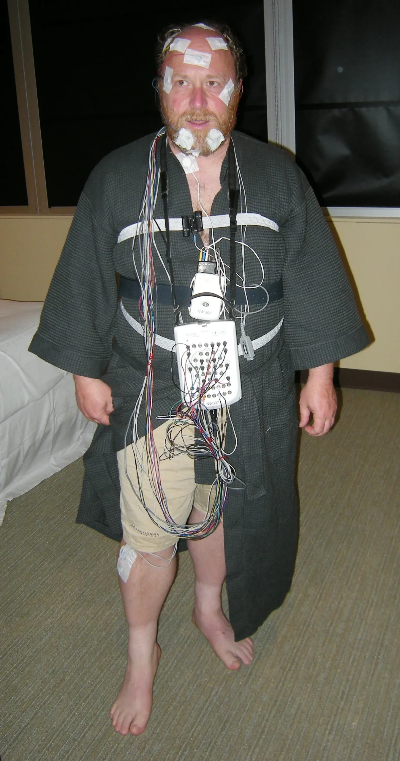 A volunteer wired with sensors during a sleep study in a laboratory